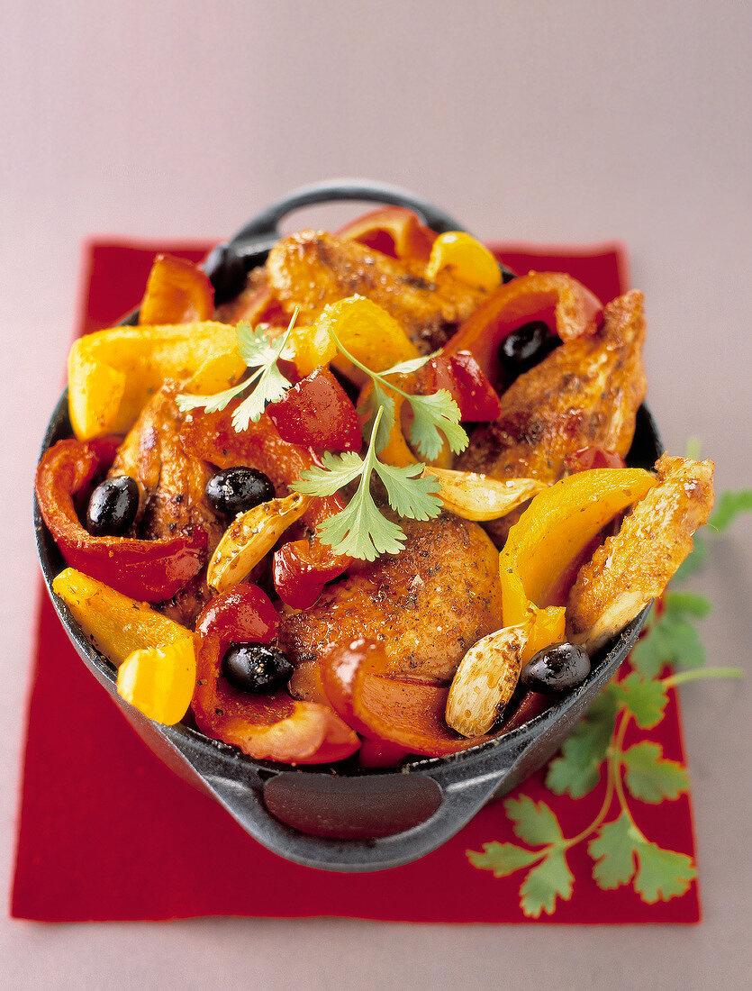 Caramelized chicken with red and yellow peppers and black olives