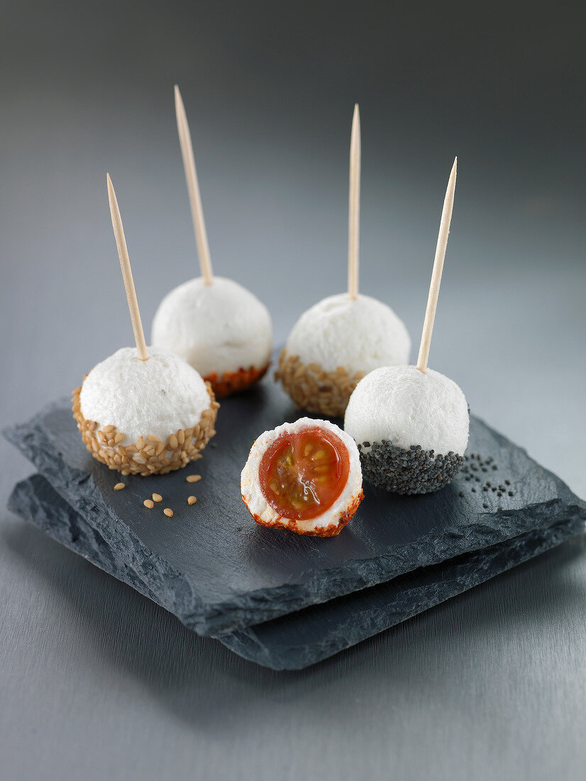 Cherry tomato and cheese balls coated with sesame seeds or poppy seeds