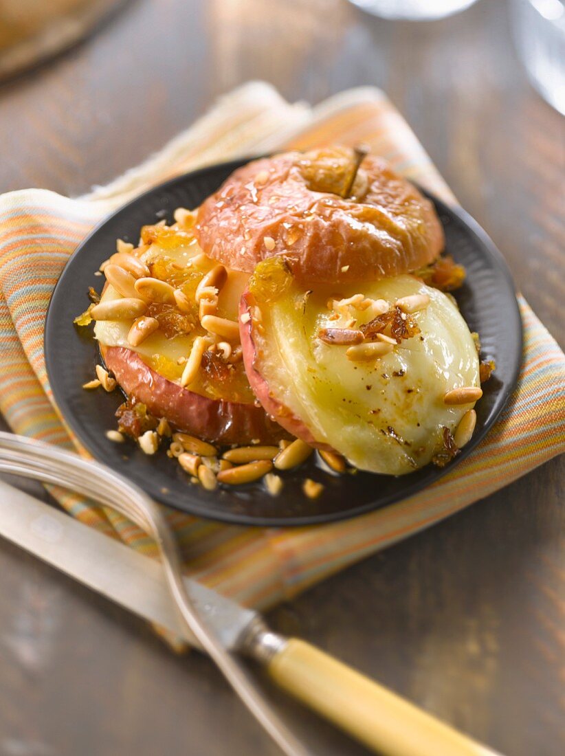 Baked apple with goat's cheese, honey, pinenuts and grapes