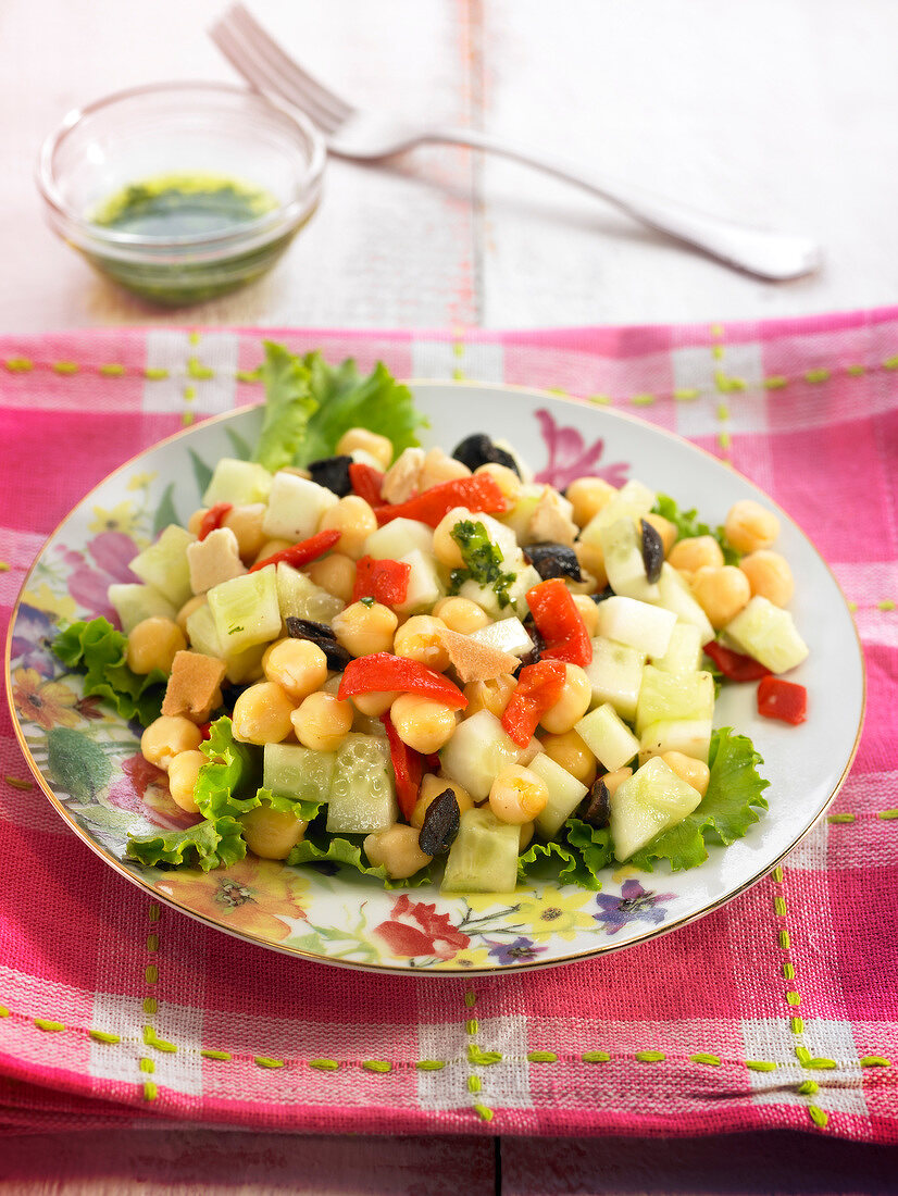 Salat mit Kichererbsen, Gurke, Oliven und roter Paprika