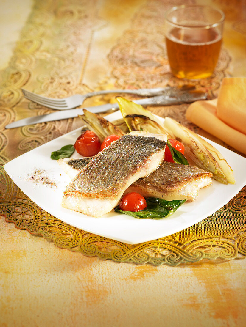 Grilled sea bream fillets with chicory, spinach and cherry tomatoes