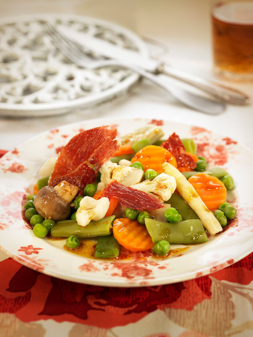Cooked vegetable salad with spanish ham
