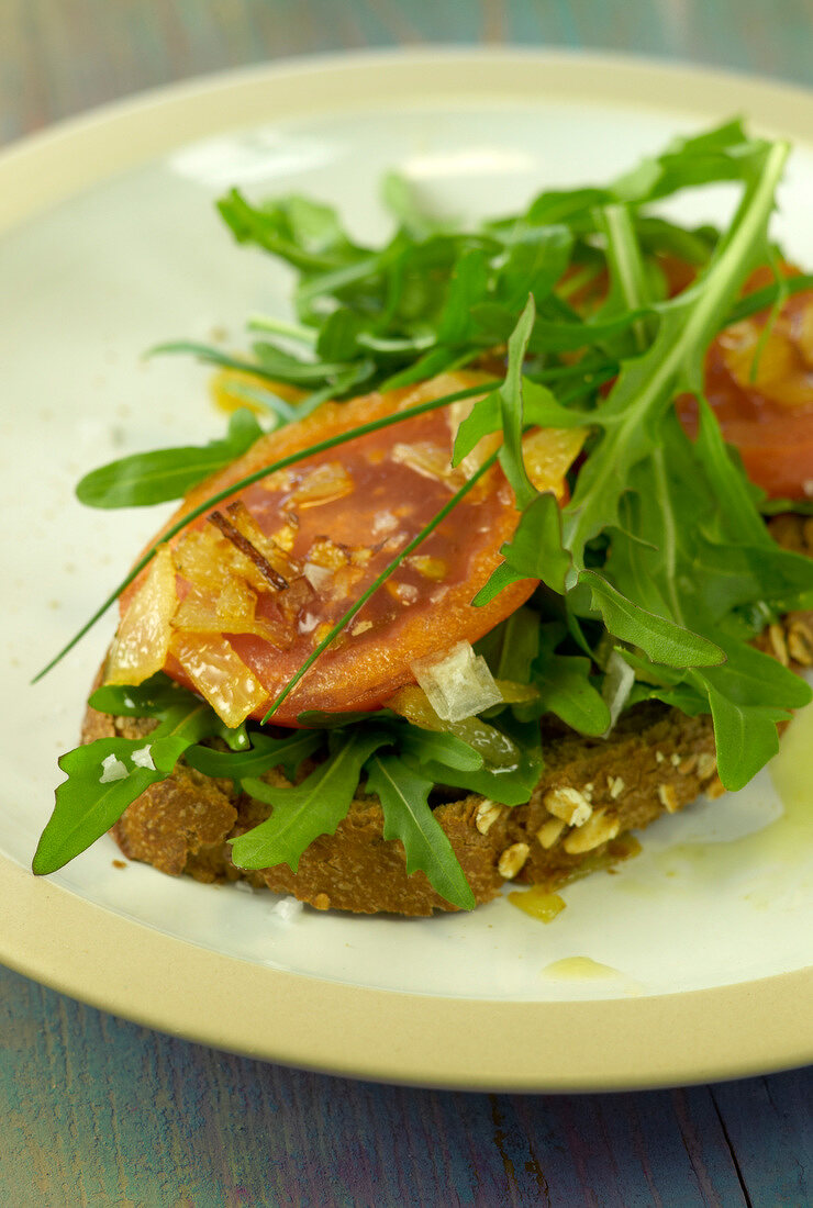 Gebratene Tomaten mit Rucola auf Roggenbrot