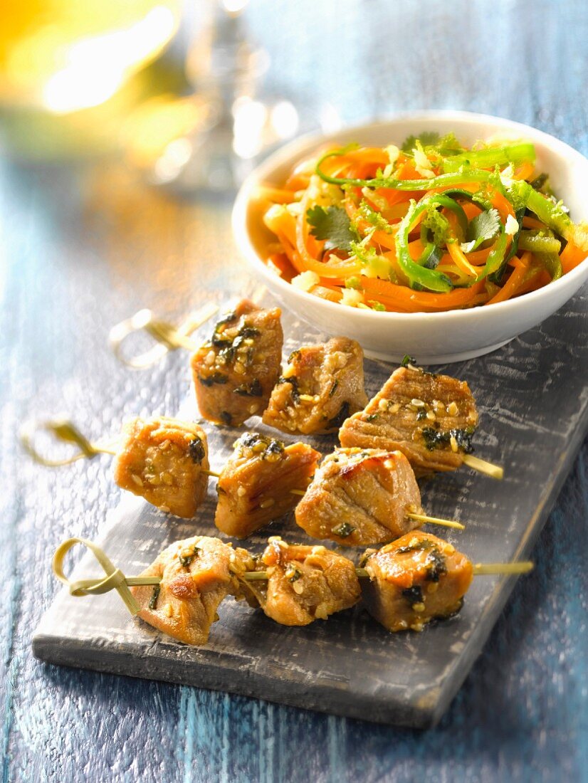 Pork brochettes marinated in soya sauce and vegetable strips in citrus fruit juice