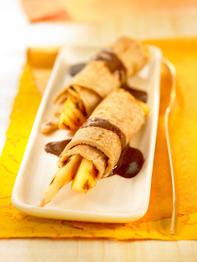 Rolled pancakes with dried fruit and chocolate sauce