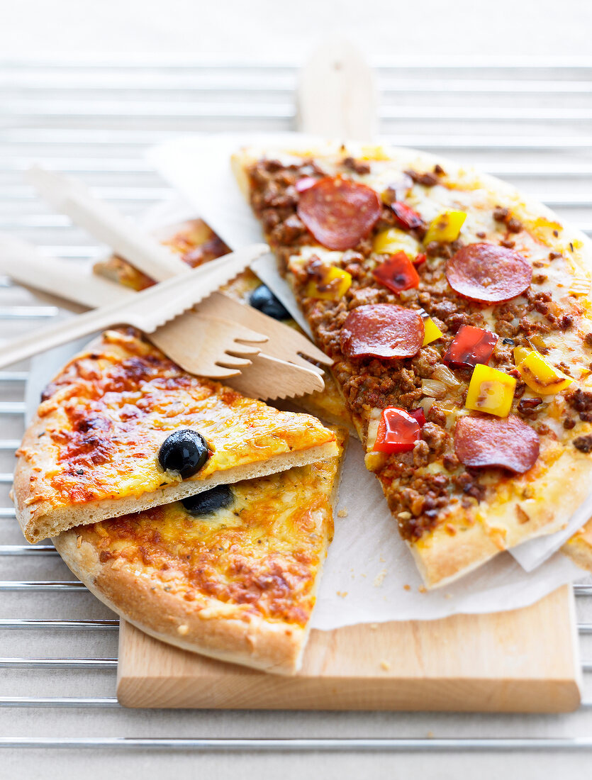 Verschiedene Pizzastücke auf einem Holzschneidebrett