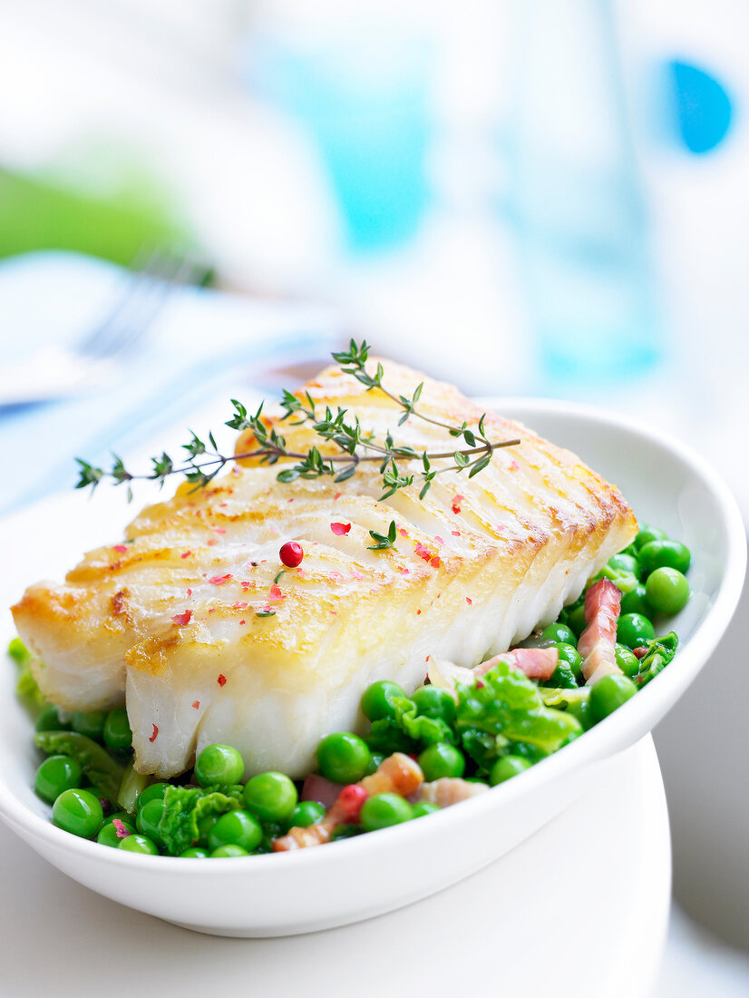 Piece of cod with thyme and pink peppercorns,peas with diced bacon