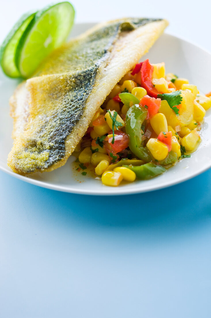 Gebratenes Barschfilet mit Mais-Paprikasalat und Limettenscheiben