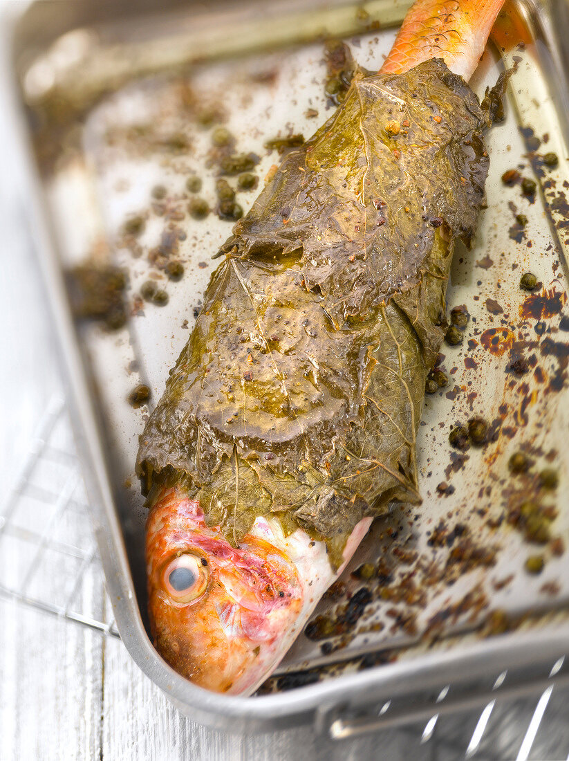 Grilled red mullet wrapped in vine leaves