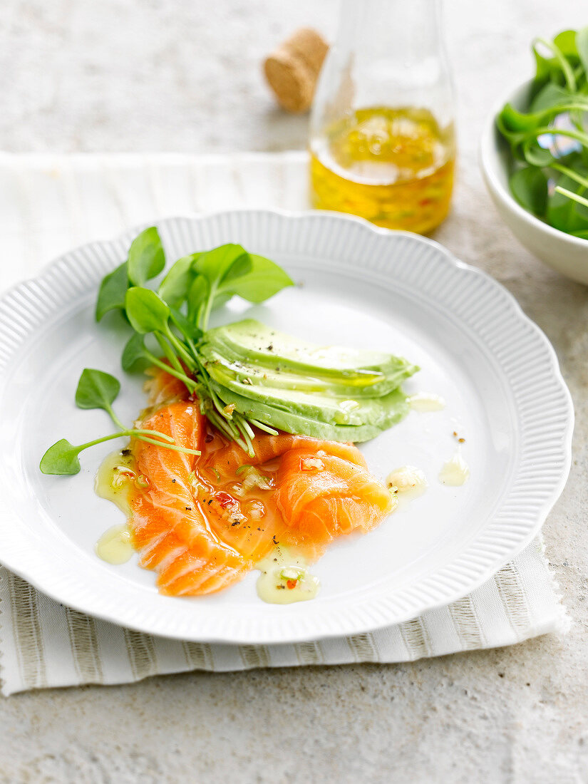 Spicy salmon carpaccio with avocado and watercress