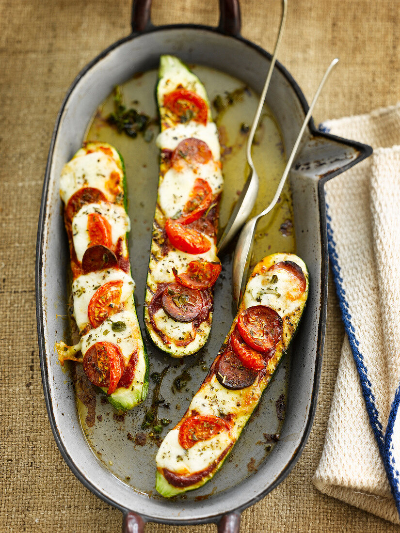 Oven-baked zucchinis stuffed with mozzarella and tomatoes