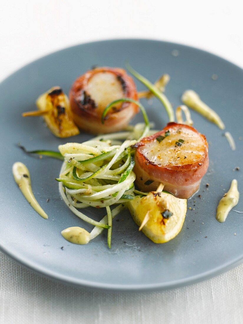 Scallops wrapped in bacon and sliced zucchinis
