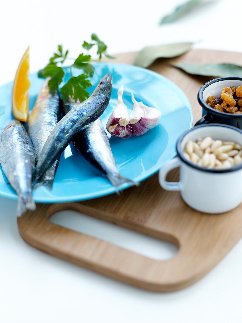 Ingredients for stuffed sardines with pine nuts,raisins,bay leaves and orange sauce