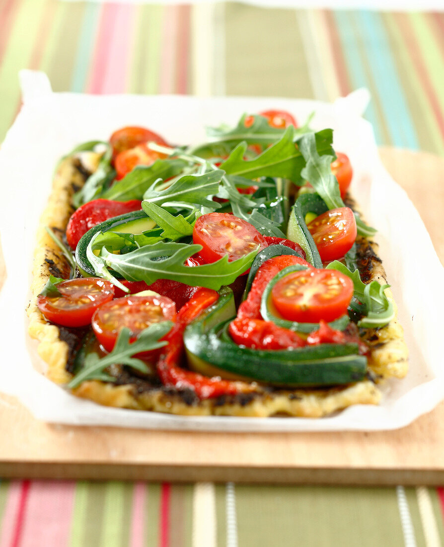 Tarte mit Tapenade, Tomaten, Zucchini und Rucola