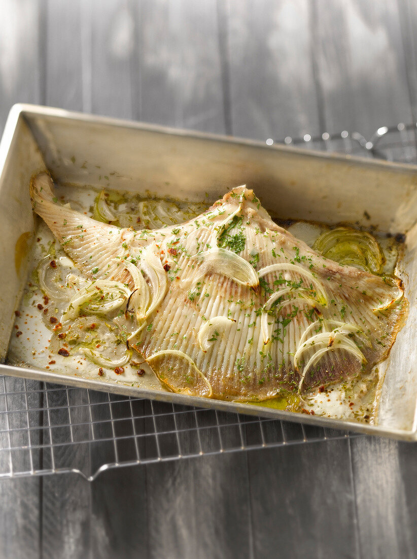 Oven-baked skate with onions and herbs