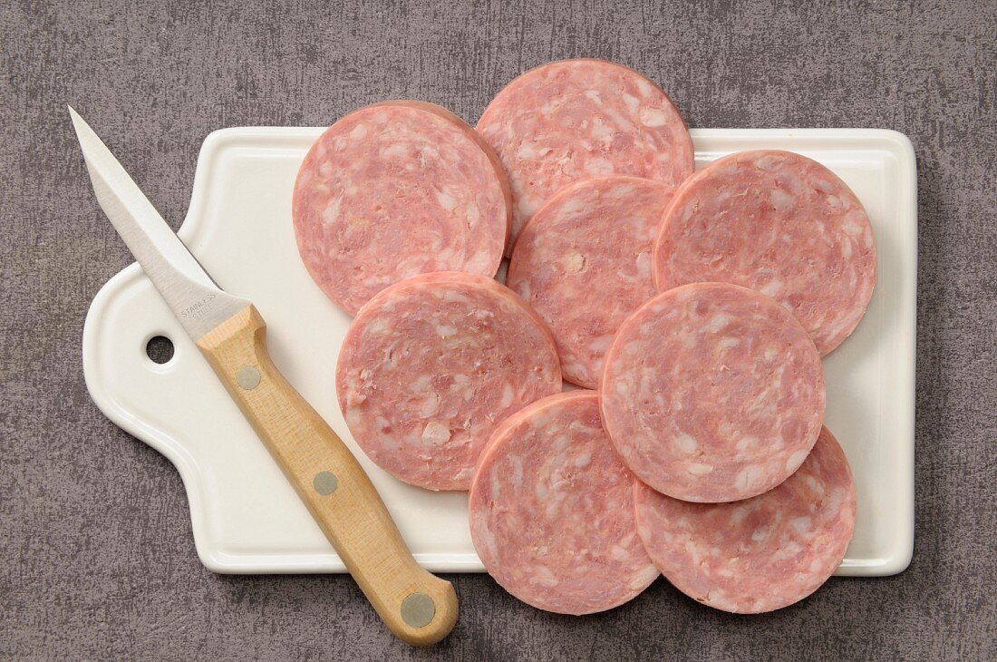 Sliced garlic sausage on a chopping board