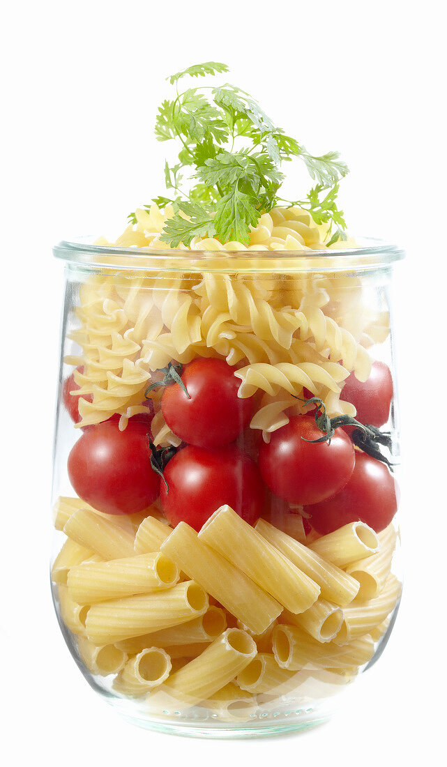Uncooked pasta and cherry tomatoes in a jar
