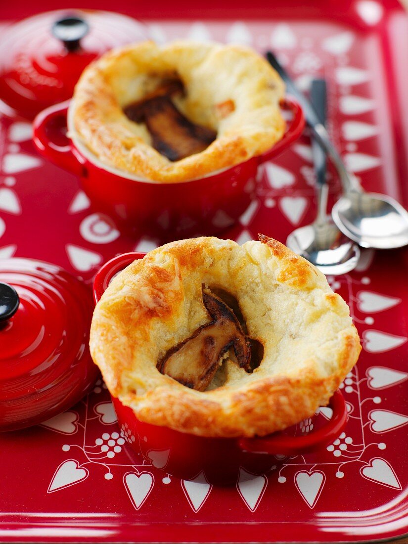 Small casserole dishes of aged Comté and caep soufflé