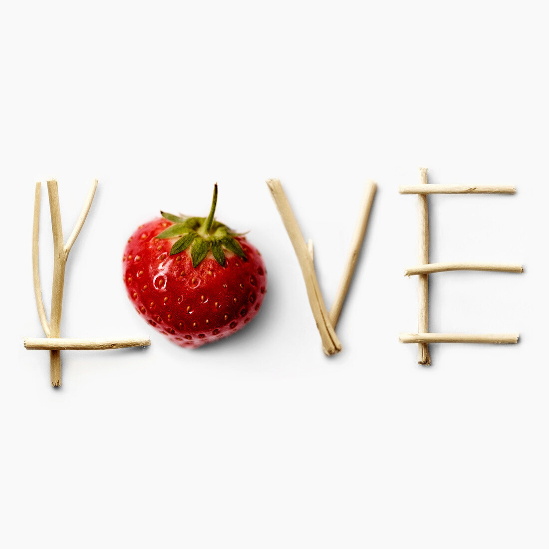 LOVE, mit Zweigen und Erdbeere geschrieben