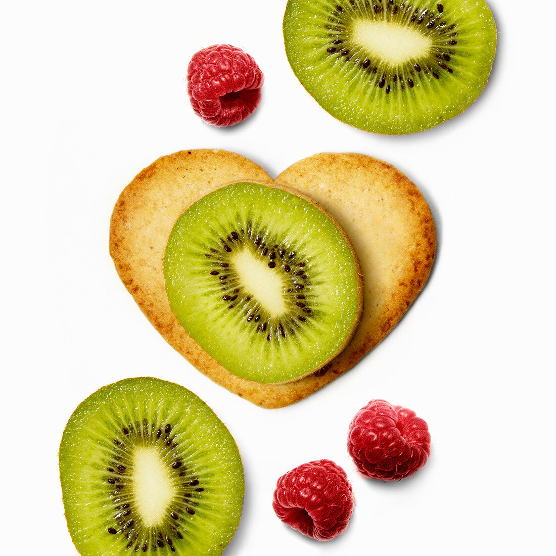 Heart-shaped biscuit with sliced kiwis and raspberries