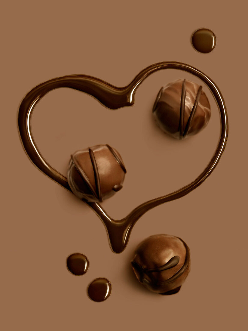 Herzform aus Schokolade und drei Pralinen