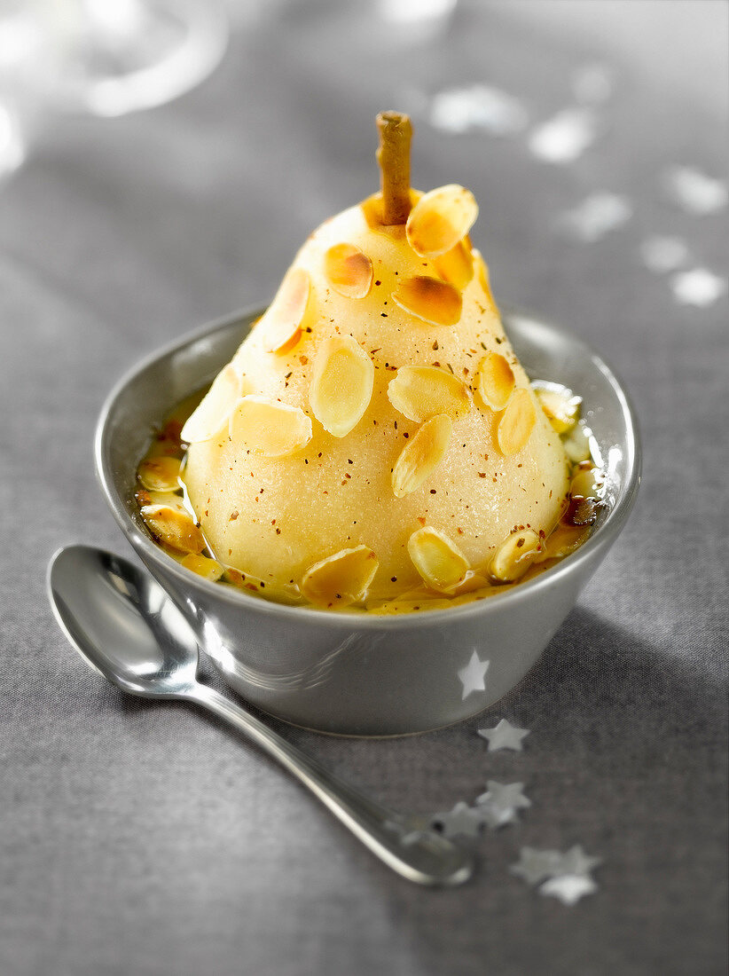 Pear poached in a licorice infusion and sprinkled with thinly sliced roasted almonds
