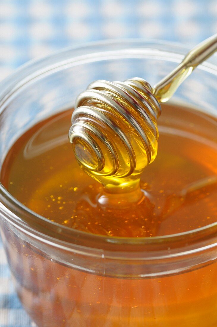 Honey spoon on a pot of honey