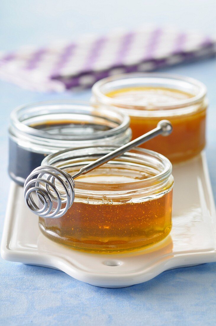 Pots of honey and honey spoon