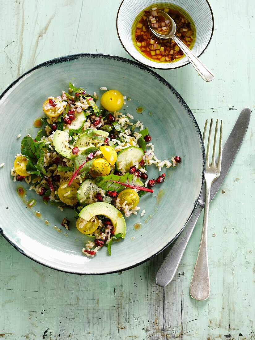 Rice,pomegranate,red and yellow cherry tomato and avocado salad