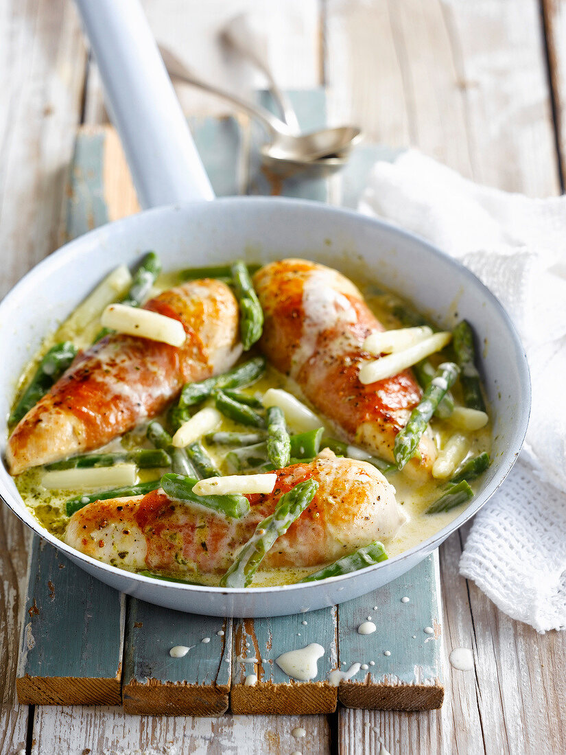 Chicken breasts in creamy sauce with green and white asparagus