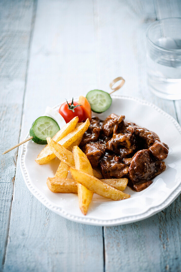 Putengulasch mit Gemüsespießen und Pommes frites