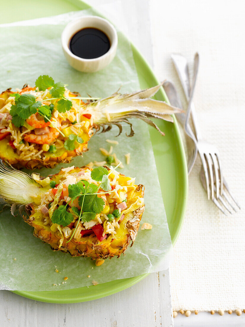 Thailändischer Shrimp-Reissalat mit frischem Koriander in Ananashälften serviert