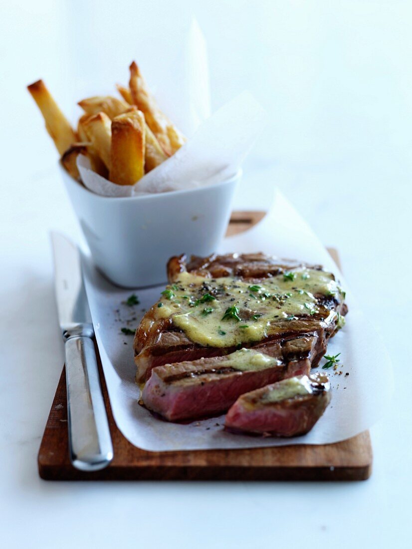 Piece of grilled beef with butter and french fries