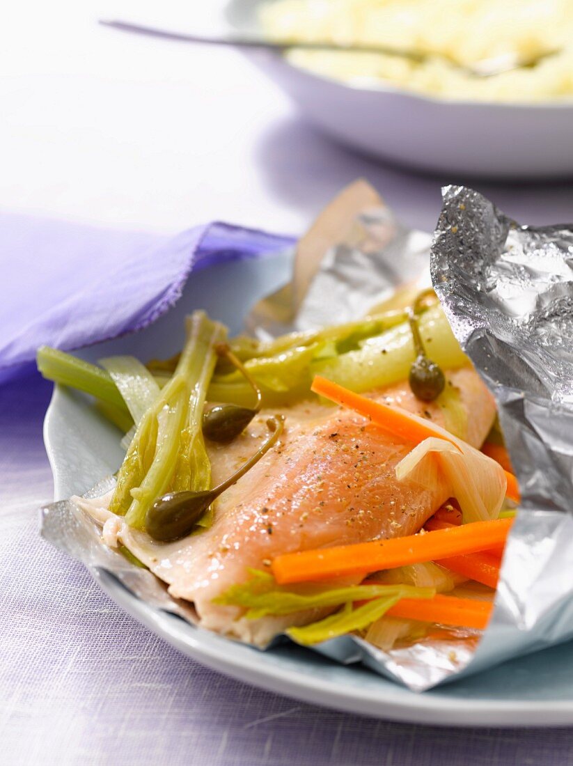 Trout with capers and vegetables cooked in aluminium foil
