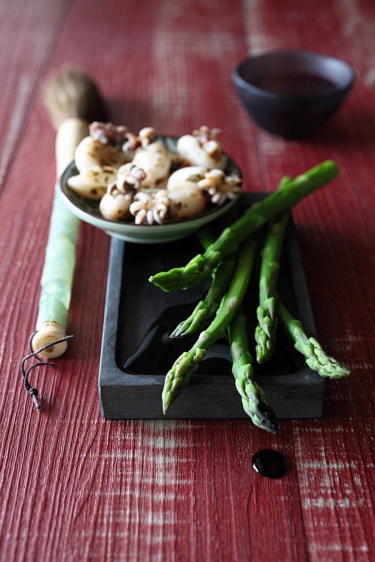 Green asparagus,small squid with their ink and a Chinese painting brush