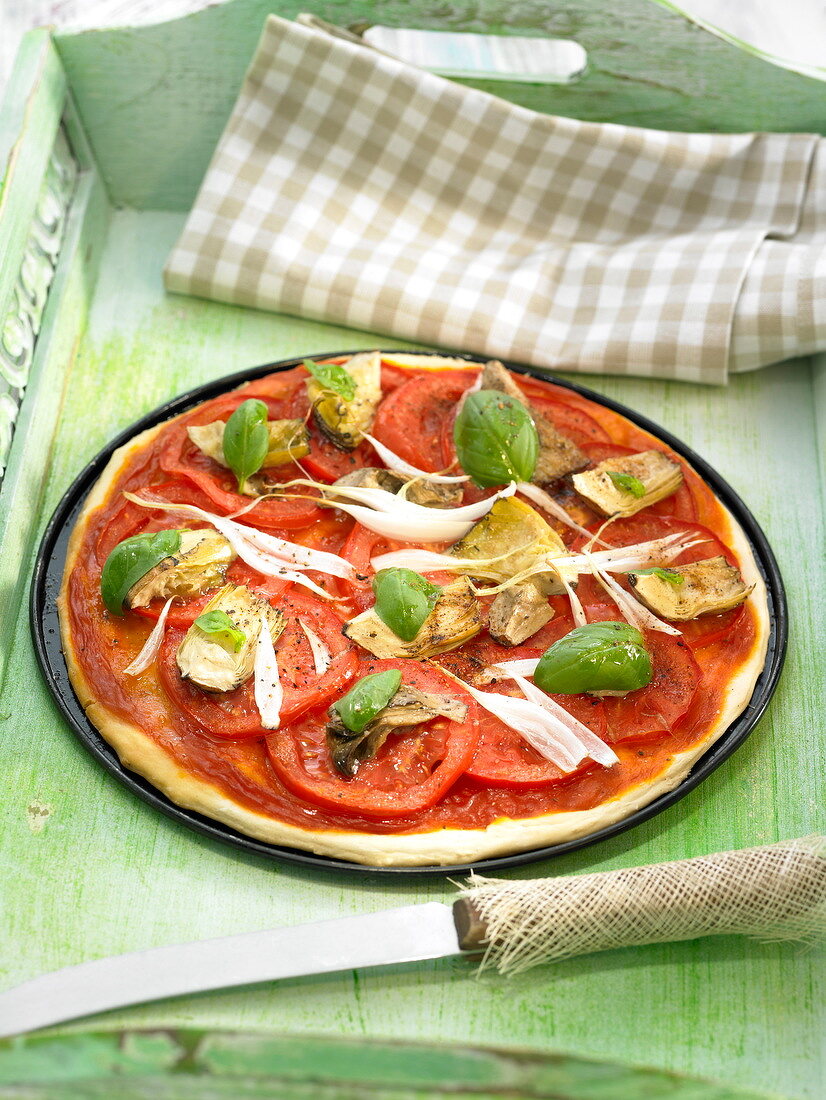 Pizza mit Tomaten, Artischocken und Basilikum
