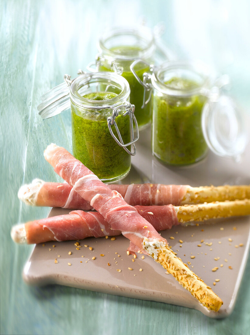 Raw ham sesame bread sticks and Pesto