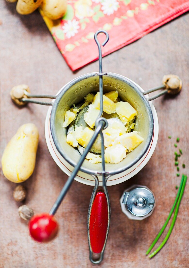 Kartoffeln in einer Kartoffelpresse stampfen