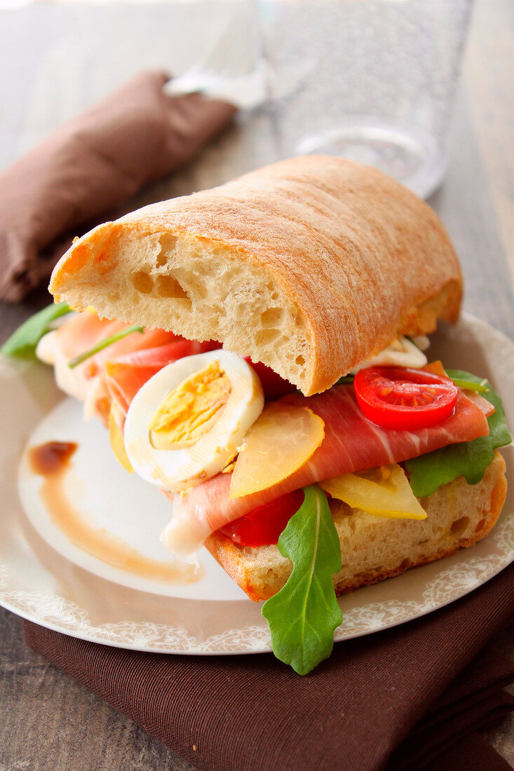 Ciabatta-Sandwich mit Parmaschinken, Gemüse und Ei