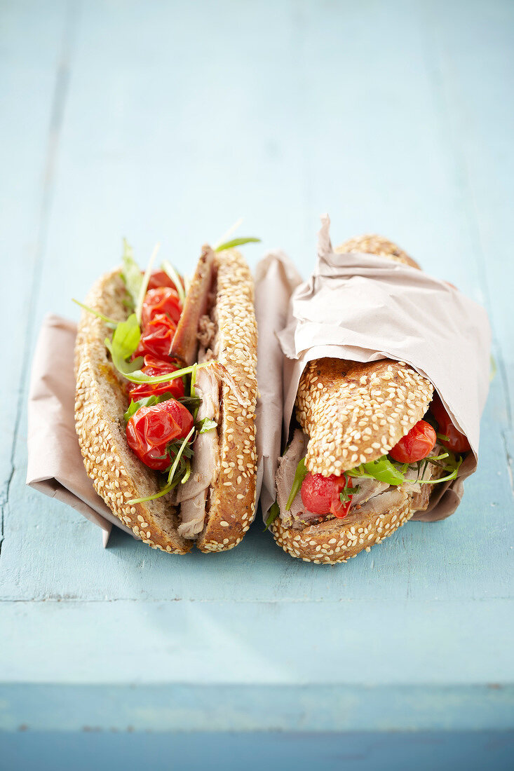 Kornbrötchen-Sandwich mit Schweinebraten und Tomaten