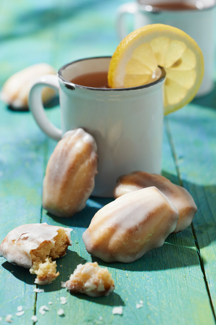 Madeleines with frosting and a cup of lemon tea