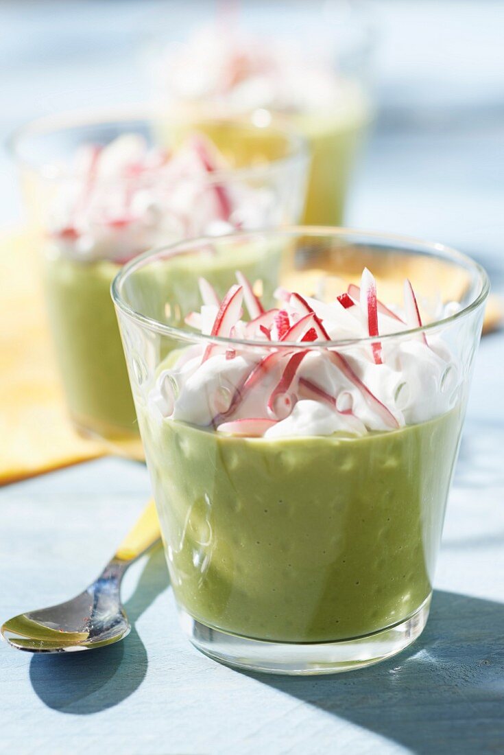 Cream of pea soup with salty whipped cream and thinly chopped radishes