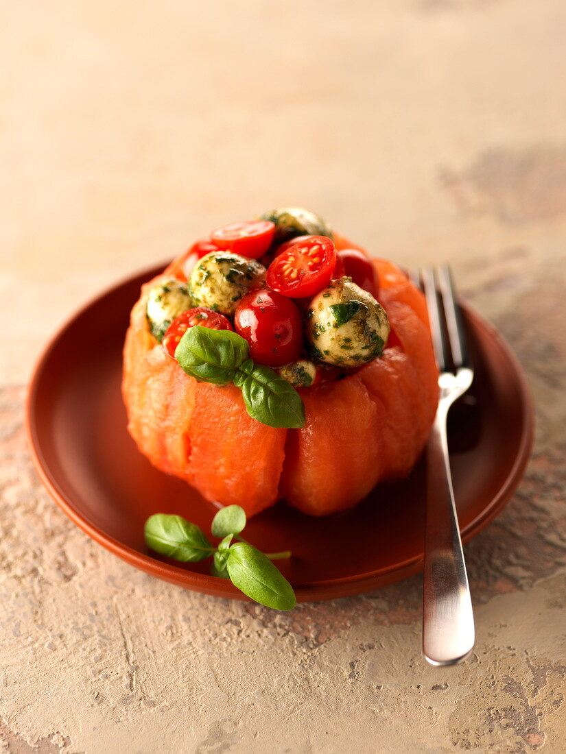 Caprese salad served in a Coeur de boeuf tomato