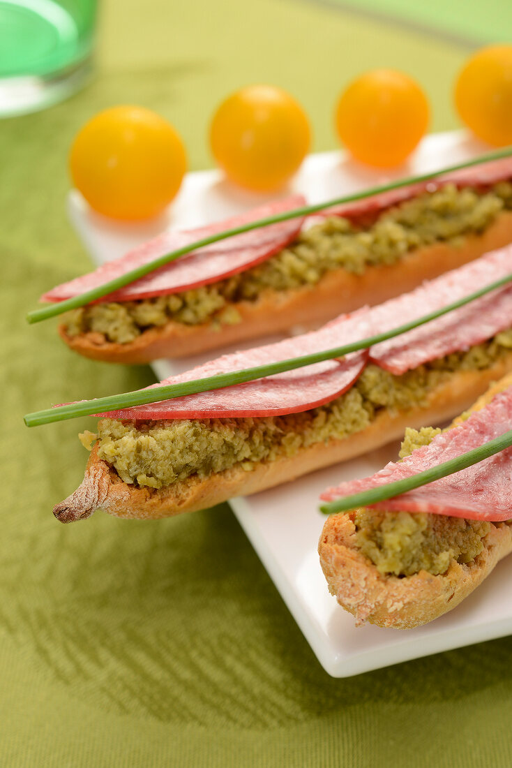 Green olive caviar, salami and chive open sandwiches