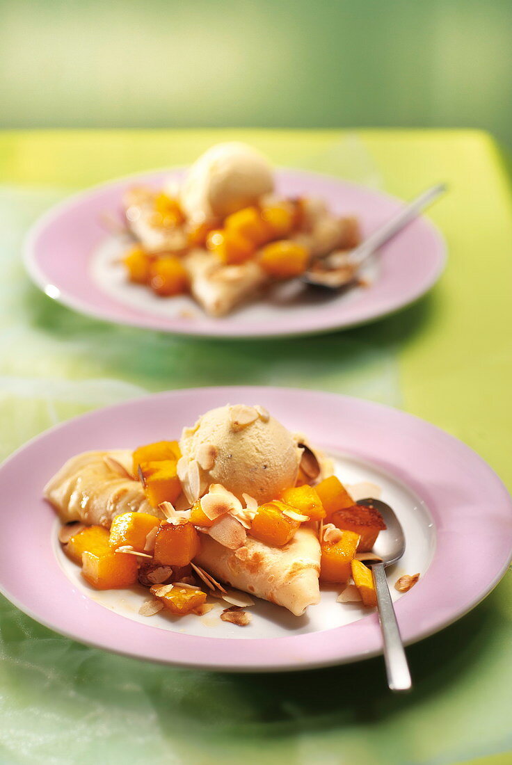 Crepes with diced mango, thinly sliced almonds and vanilla ice cream