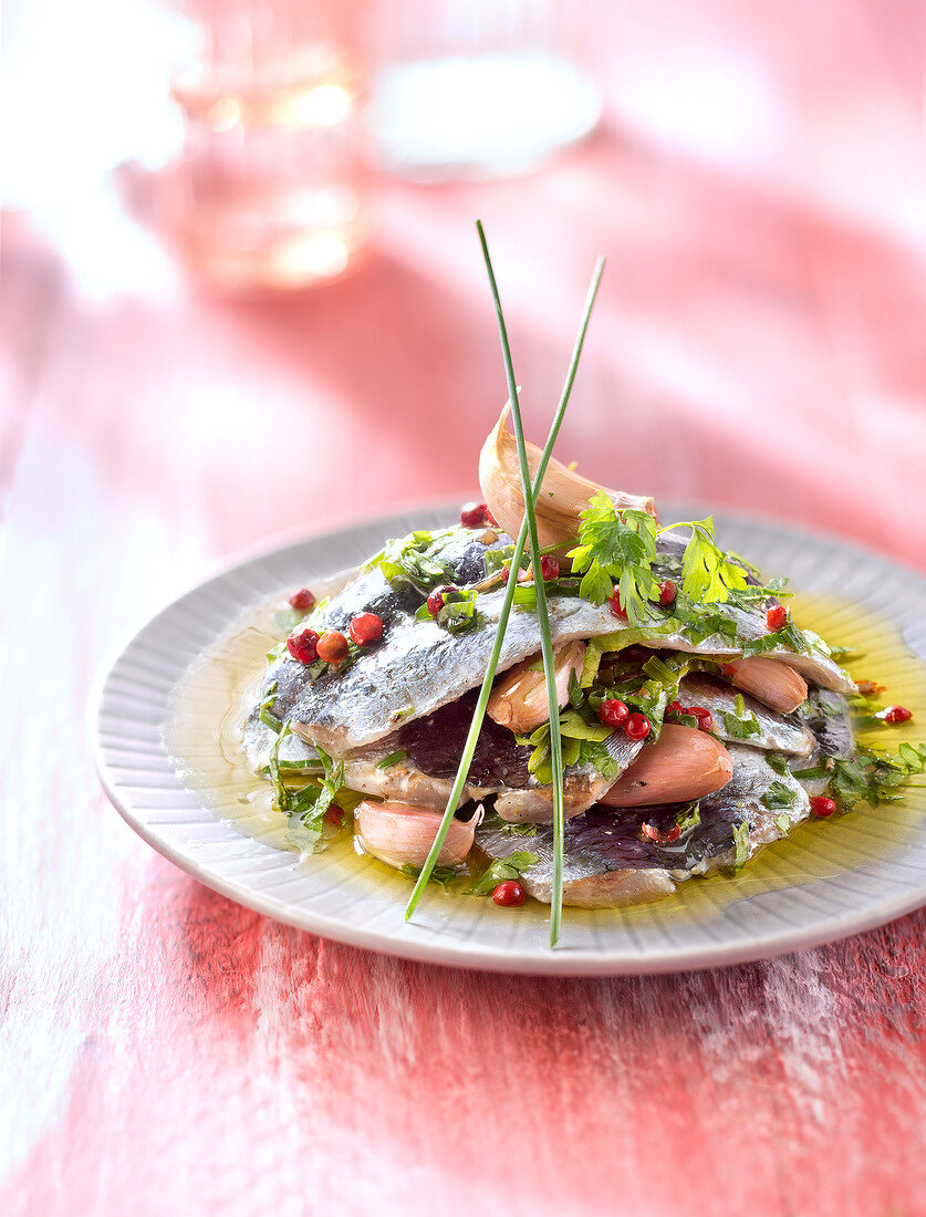 Sardinenfilets mariniert mit Olivenöl, Knoblauch, Kräutern und rosa Pfefferbeeren