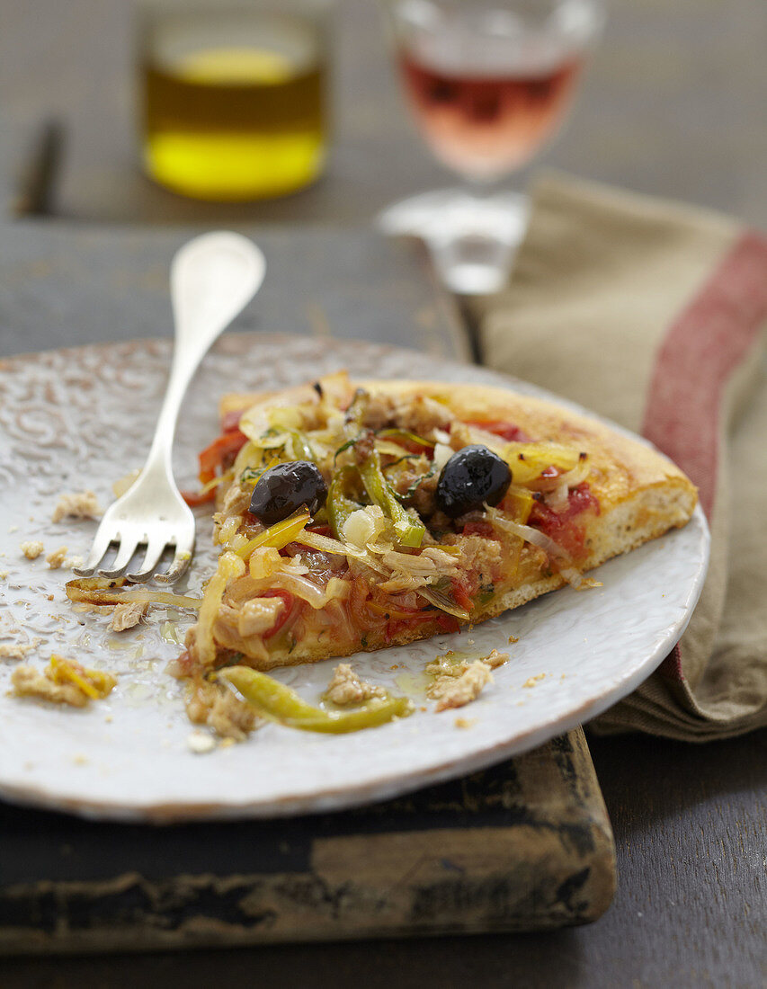 Ein Stück Pizza mit Thunfisch, Paprika und schwarzen Oliven