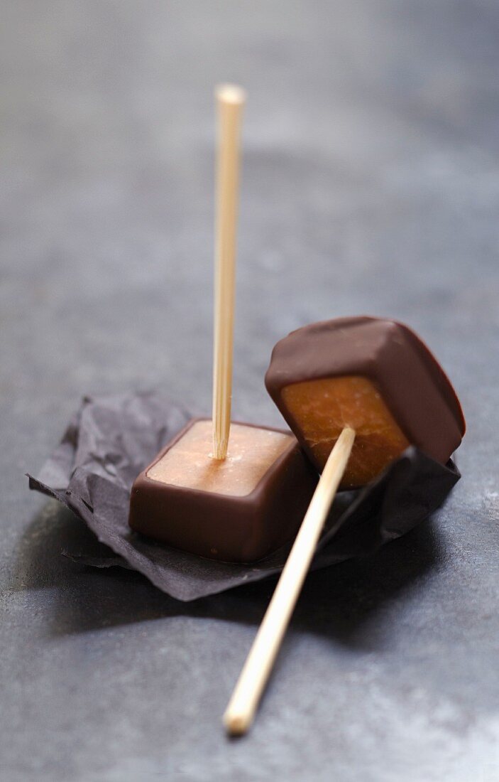 Chocolate coated toffees on sticks