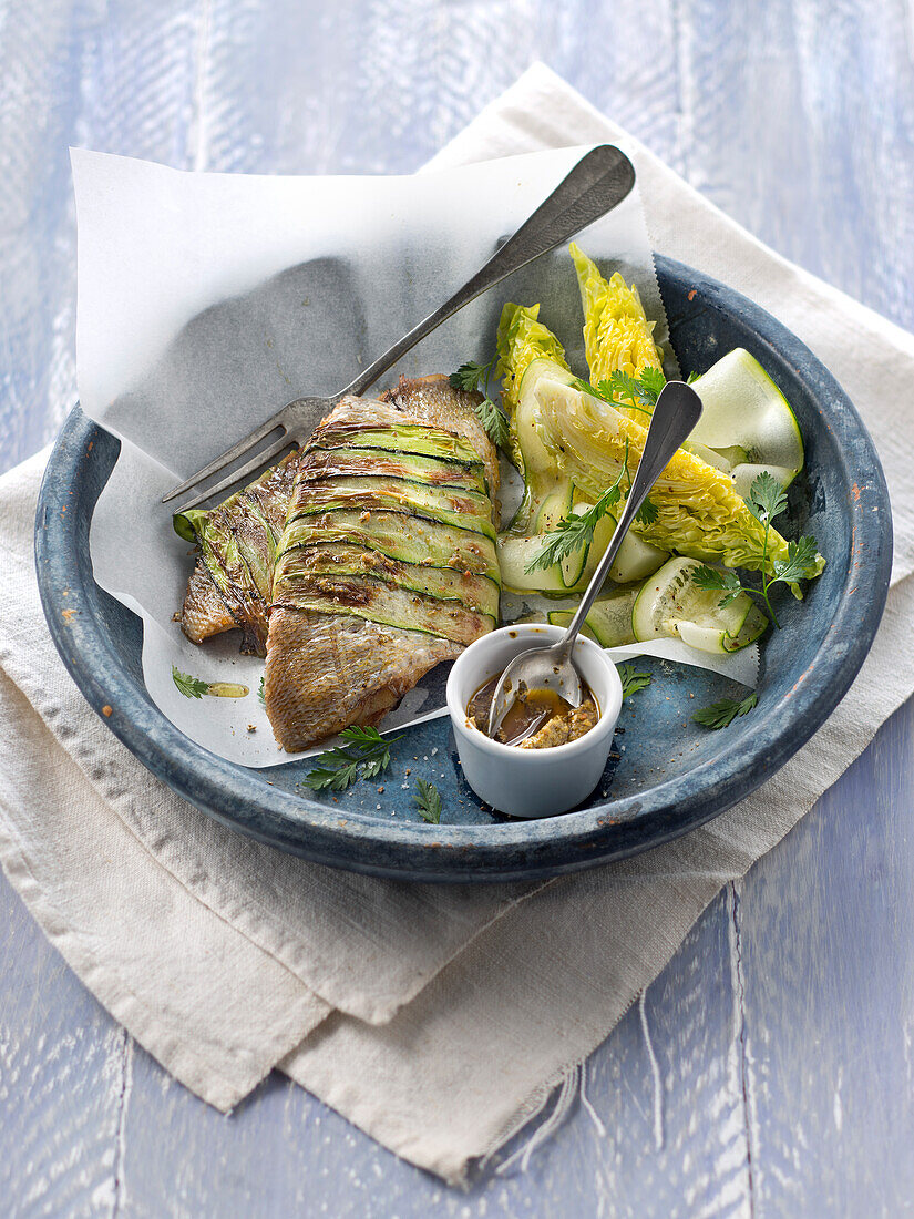Sea bream fillets wrapped in thin strips of zucchinis,lettuce salad and pesto sauce