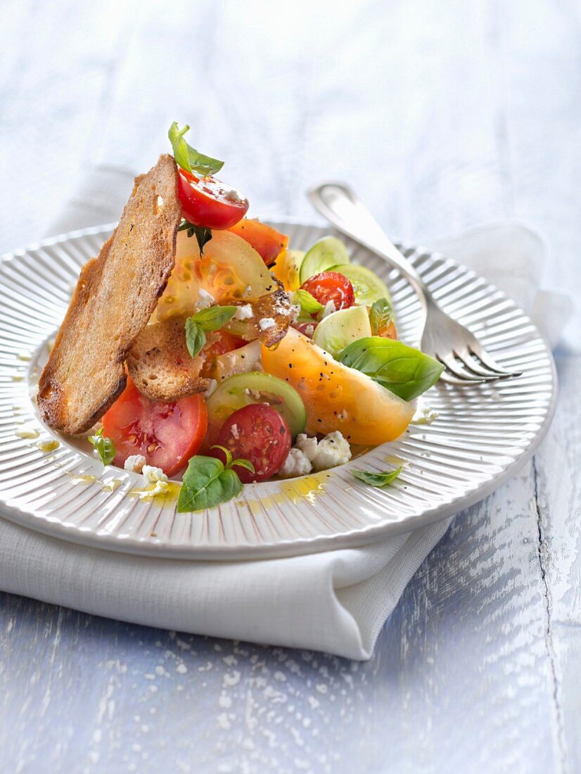 Multicolored tomato and feta salad with farmhouse bread crisps